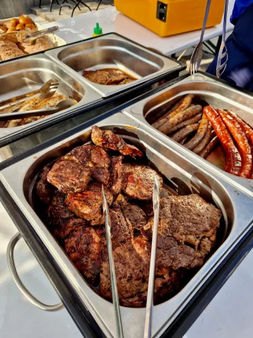 Grillbuffet mit Steaks und Würstchen im Freien.
