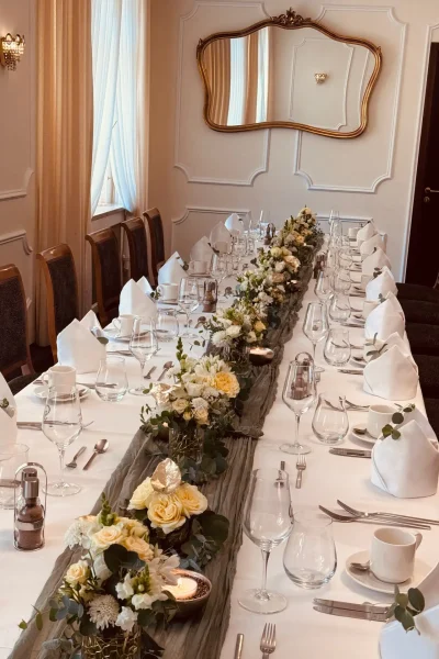 Festlich gedeckte Tafel mit weißer und cremefarbener Blumendekoration im Barockzimmer des Goldenen Pflugs in Ludwigsburg.