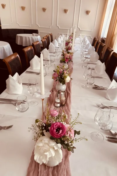 Festlich gedeckte Tafel mit rosa Tischläufer, Blumen und Kerzen im Barockzimmer des Goldenen Pflugs in Ludwigsburg.