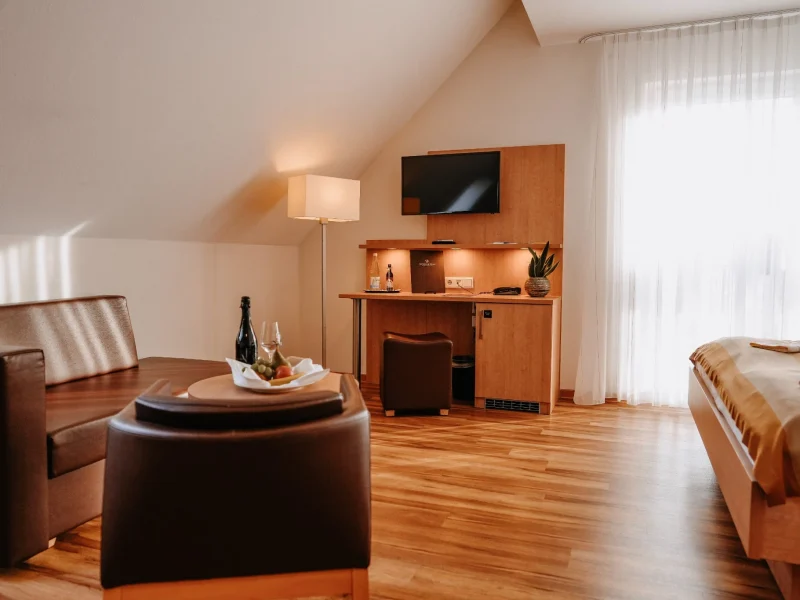 Wohnbereich mit Sofa, Sesseln und Schreibtisch im Doppelzimmer Komfort des Hotel Goldener Pflug Ludwigsburg
