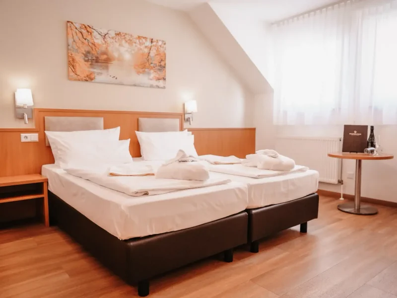 Doppelzimmer Standard mit zwei zusammengestellten Betten und Bademänteln im Hotel Goldener Pflug Ludwigsburg