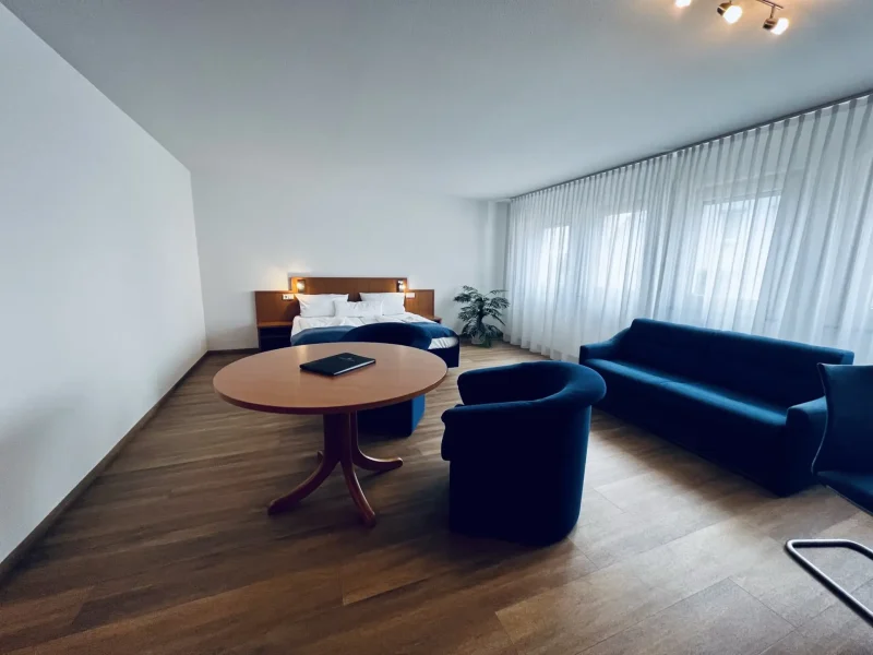 Großzügiges Doppelzimmer Superior mit Doppelbett, Sofa, Sesseln und Tisch im Hotel Goldener Pflug Ludwigsburg
