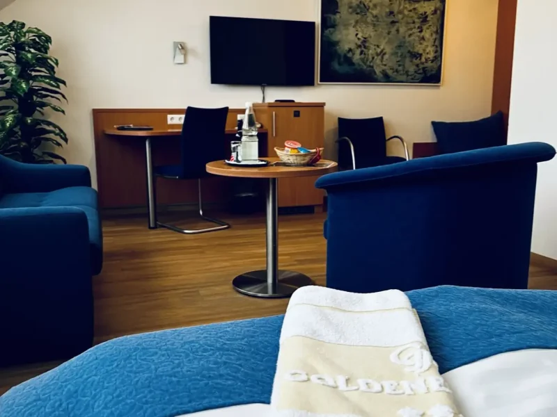 Sitz- und Arbeitsbereich mit Sofa, Sesseln, Schreibtisch und TV im Doppelzimmer Superior des Hotel Goldener Pflug Ludwigsburg