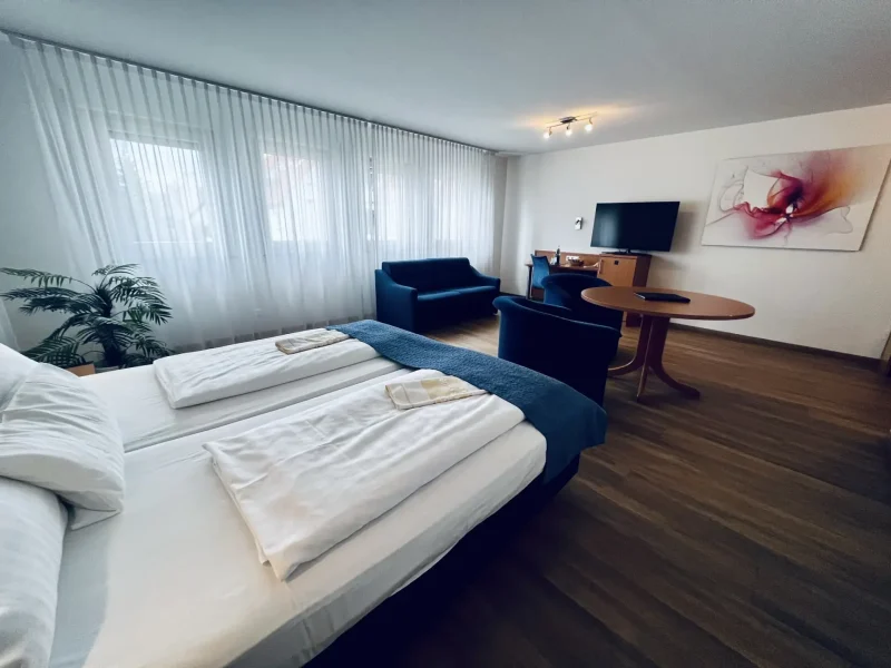 Doppelzimmer Superior mit großzügigem Wohnraum, Sofa, Sesseln und TV im Hotel Goldener Pflug Ludwigsburg