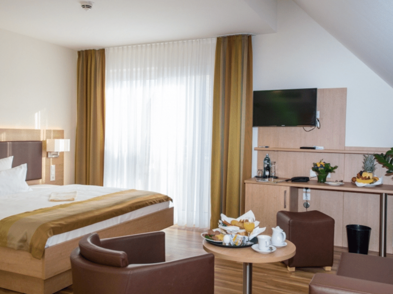 Großzügiges Doppelzimmer Komfort mit Doppelbett, Sitzbereich und TV im Hotel Goldener Pflug Ludwigsburg