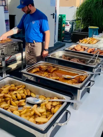 Mann bedient Grillstand mit verschiedenen Speisen.