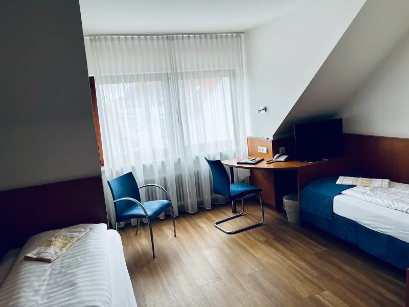 Twinzimmer mit zwei getrennten Einzelbetten, Sitzbereich und Schreibtisch im Hotel Goldener Pflug Ludwigsburg