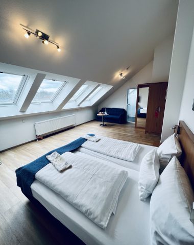 Helles Dachgeschosszimmer mit Doppelbett und Einrichtung