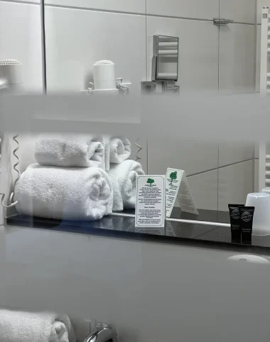 Moderne Hotelbadezimmerausstattung mit Handtüchern und Pflegeprodukten.