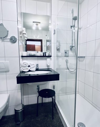 Modernes Badezimmer mit Dusche und Waschtisch.