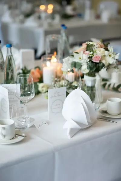 Festlich gedeckter Tisch mit Blumen, Kerzen, Gläsern und weißer Tischwäsche im Saal des Goldenen Pflugs in Ludwigsburg.