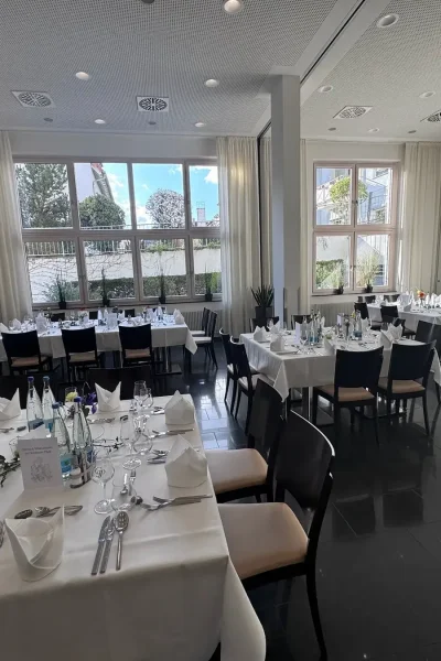 Großzügiger Saal im Goldenen Pflug Ludwigsburg mit mehreren gedeckten Tafeln und flexibler Tischanordnung.
