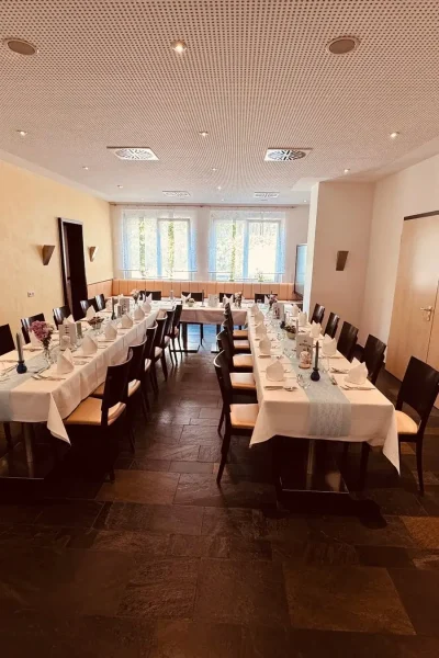 U-förmig gestellte Festtafel in den Salons des Goldenen Pflugs in Ludwigsburg mit weißer Tischwäsche und festlicher Dekoration.