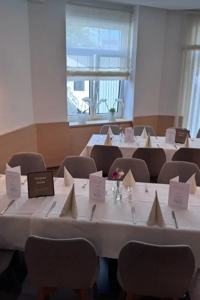 Festlich eingedeckte Tische mit grauen Stühlen im Raum Tisch 19 des Goldenen Pflugs in Ludwigsburg.