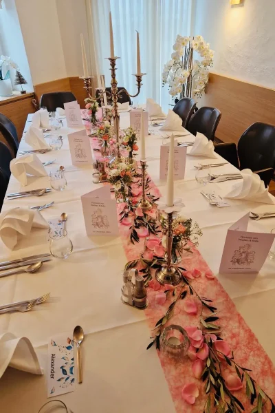 Festlich gedeckte Hochzeitstafel mit rosa Tischdekoration, Kerzenleuchtern und Blumen im Raum Tisch 19 in Ludwigsburg.