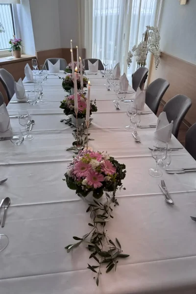 Gedeckte Festtafel mit rosa Blumen, Kerzen und moderner Bestuhlung im Raum Tisch 19 in Ludwigsburg.