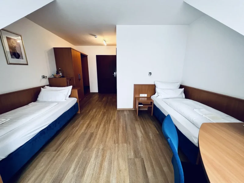 Twinzimmer mit zwei getrennten Einzelbetten und Holzboden im Hotel Goldener Pflug Ludwigsburg