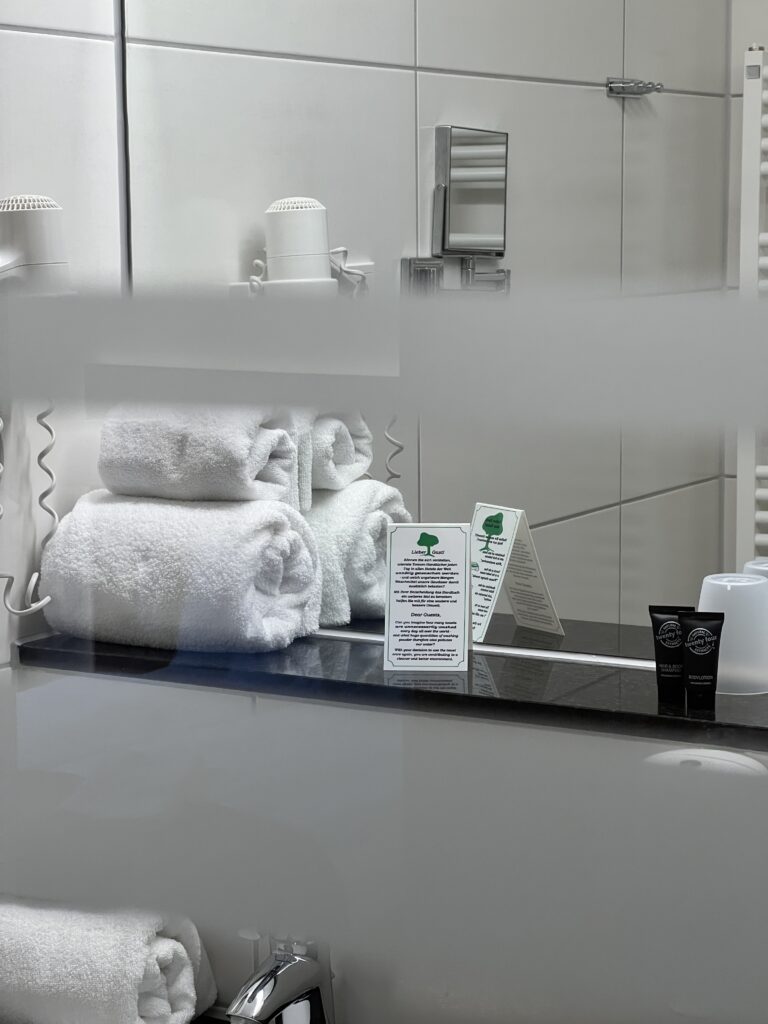 Moderne Hotelbadezimmerausstattung mit Handtüchern und Pflegeprodukten.