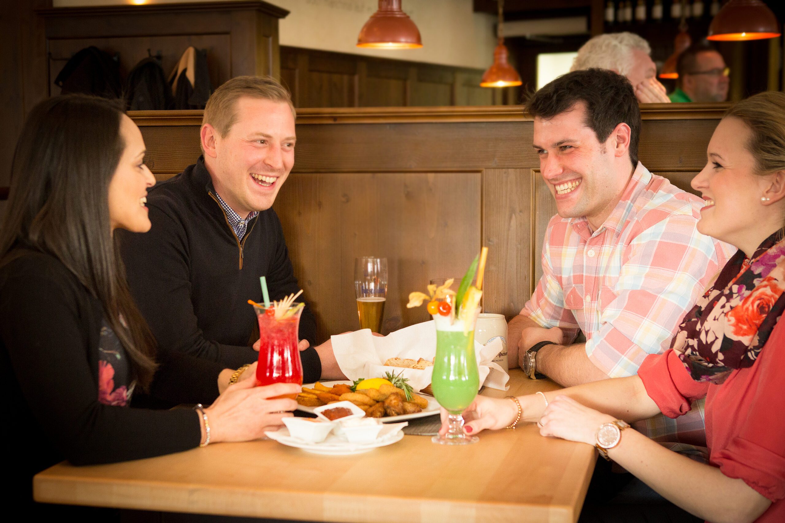 Freunde beim Lachen und Essen im Restaurant.