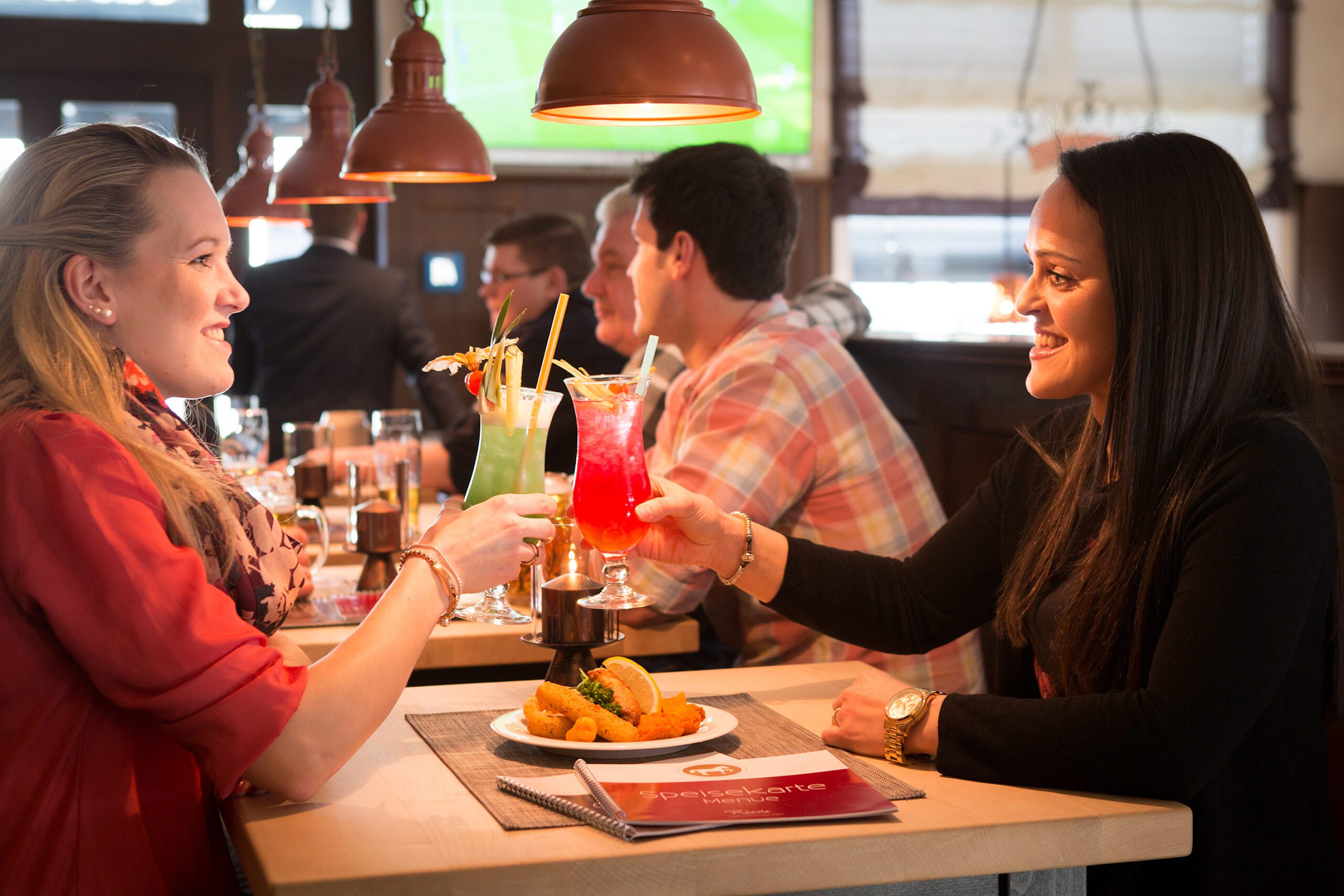Freundinnen genießen Cocktails in einer Bar.
