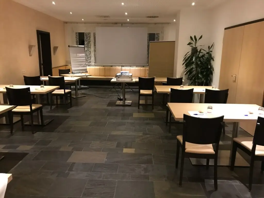 Seminarraum im Hotel Goldener Pflug Ludwigsburg mit Tischgruppen, Leinwand und Flipchart