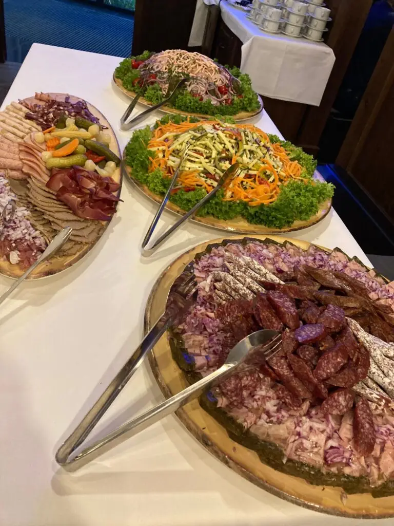 Gedeckte Tafel mit Wurst- und Salatplatten.