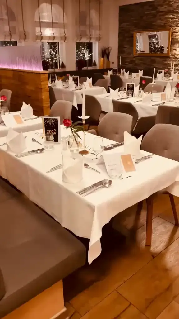 Festlich gedeckte Tische mit weißen Tischdecken, Kerzen und roten Rosen im Restaurant Goldener Pflug in Ludwigsburg.